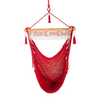 Red polyester outdoor hanging chair with fake news sign