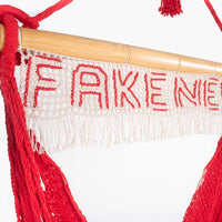Hanging red rope hammock swing chair with fake news sign